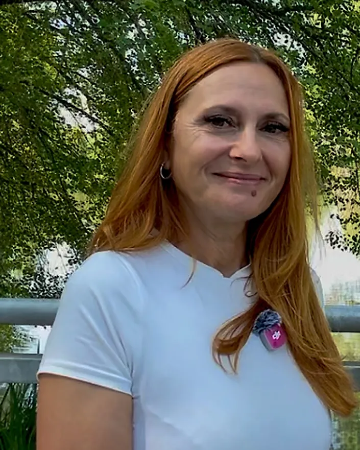 Porträt von Sonia Schmid-Greco mit roten Haaren und weißem Shirt